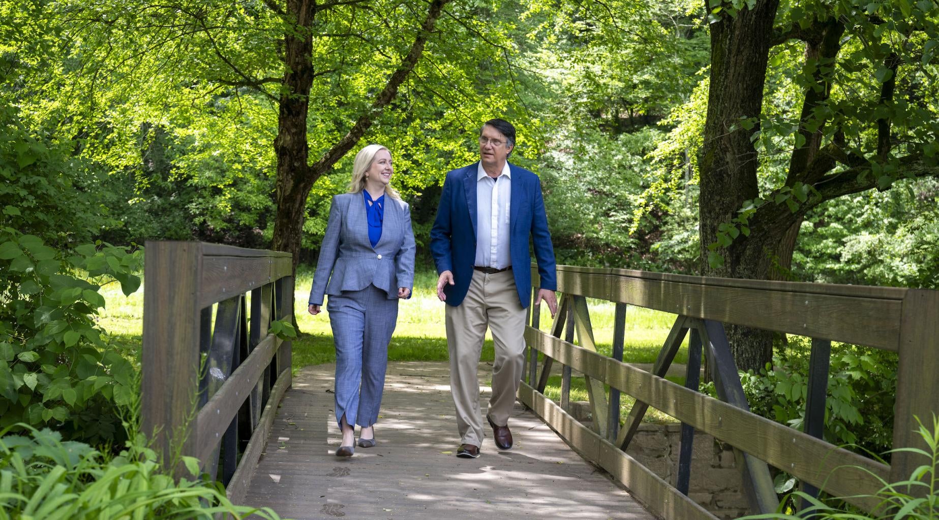 "Dean Nicola Foote and President Robert Gregerson cross bridge together on Greensburg's campus"