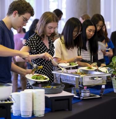 Students grab food at a carbon-tracked buffet for the 2022 Sustainability Supper hosted by the ScholarCHEF scholar community.