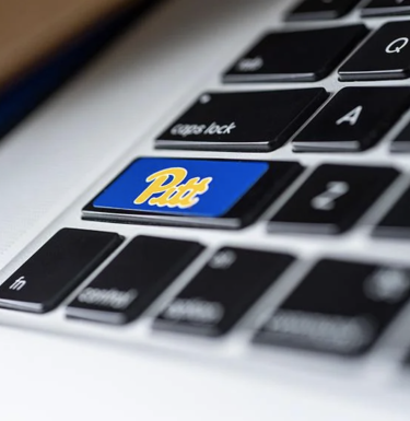 Key with Pitt script logo on laptop keyboard.